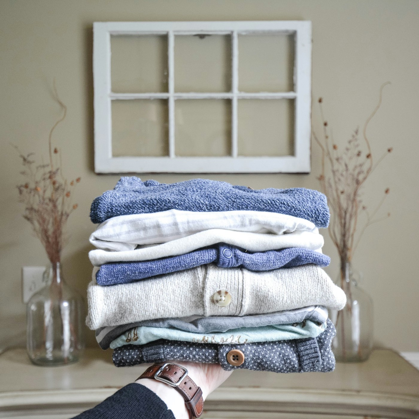 Folded stack of clothes held in hands