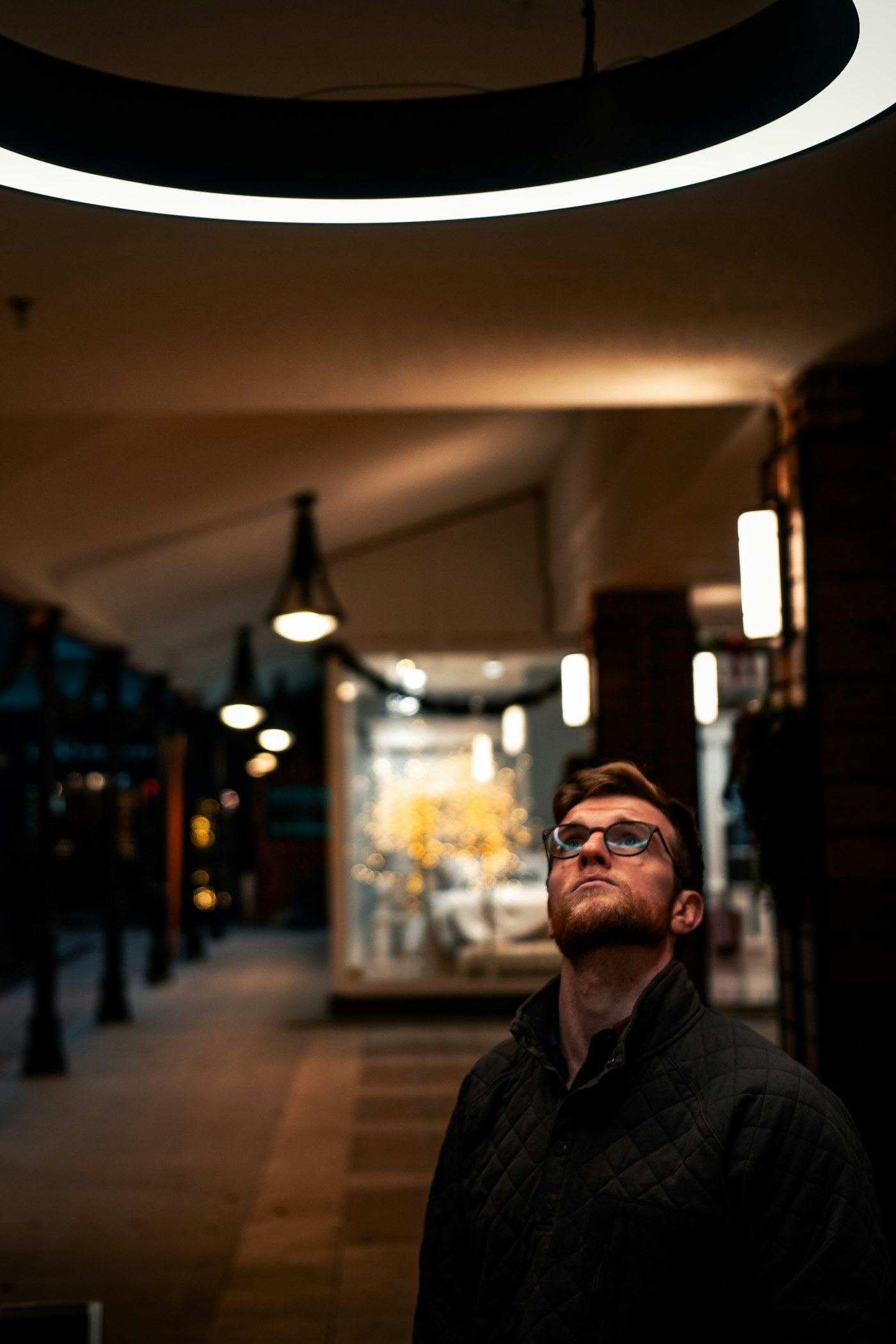 Man in a black jacket outside a storefront