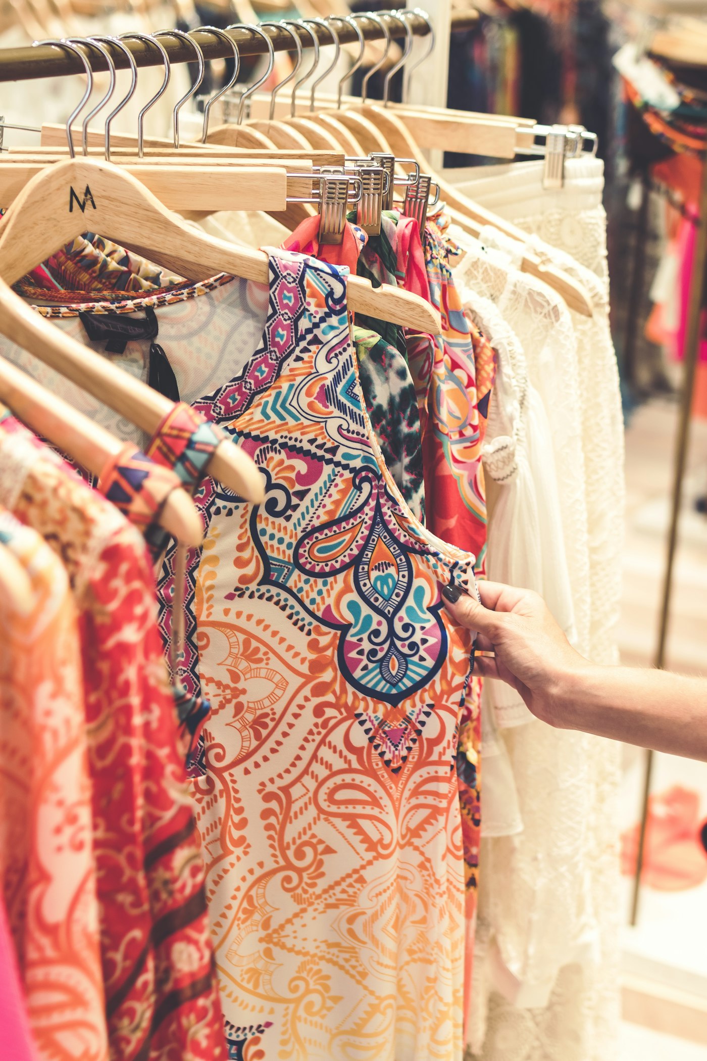 Flash-lit woman searching a rack of secondhand dresses